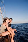 couple sitting on rail of boat