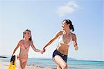 mother with daughter running along beach