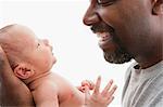 Laughing father looking at young baby