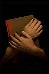 Hands clasped over book