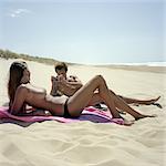 Guy photographing girl on beach