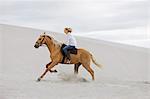 Girl riding horse on the beach