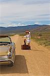 Woman hitching on desert road