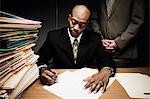 Man doing paperwork with man behind him