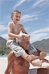 Older man with grandson on beach