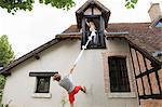 Man climbing sheet to girlfriend's room