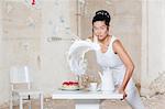 Woman pouring milk over set table