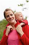 Mother carrying toddler son piggyback