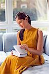 Woman opening box on sofa