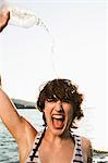 Woman pouring water on herself at beach