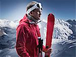 Man carrying skis on snowy mountain