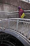 Woman climbing staircase in snow