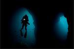 Diver swimming in underwater cave