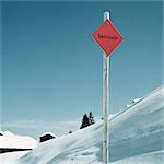 Sign reading Skiroute on snowy slopes