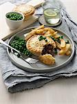 Plate of meat pie, chips and peas