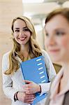 Businesswoman carrying folder in office