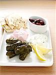 Plate of rolls, lemon, olives and bread