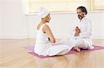 Couple meditating together on yoga mat