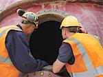 Workers examining machinery on site