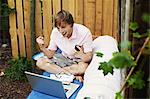 Man using laptop on sofa outdoors