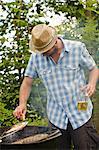 Man grilling fish on barbecue outdoors