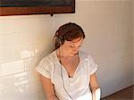 Woman listening to headphones on bench