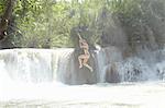 Woman jumping into rushing river