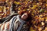 Woman laying in autumn leaves