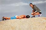 Couple laughing on boulder