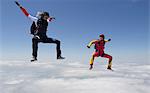 Women skydiving over clouds