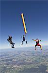 People skydiving over rural landscape