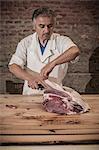 Butcher carving meat in shop