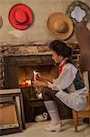 Woman lighting candles in fireplace