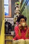 Woman drinking cup of coffee on steps