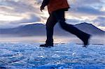 Hiker walking on ice in rural landscape