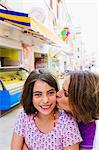 Mother kissing daughter outdoors