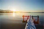 Snowy pier over still rural lake