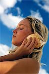 Woman listening to seashells outdoors