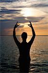 Silhouette of man meditating in water