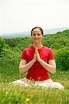 Woman meditating in grassy field