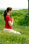 Woman meditating in grassy field