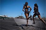 Women running together on wooden pier