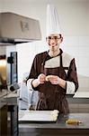 Baker shaping dough in kitchen