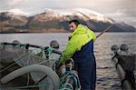 Worker at salmon farm in rural lake