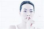 Woman covering lips with finger