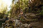 Two boys sitting on rocks in forest