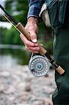 Man with fly fishing rod and reel, close up