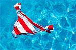 Red and white striped bikini bottoms floating on water surface