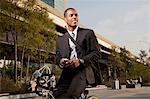 Young businessman on bicycle, smiling