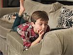 Boy playing with digital tablet on sofa